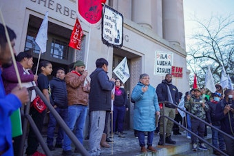 caption: Rosalinda Guillen speaks to a crowd of farmworkers on Jan. 22, 2025. Guillen and others marched to the steps of the John A. Cherberg Building in Olympia. 