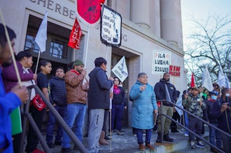 caption: Rosalinda Guillen speaks to a crowd of farmworkers on Jan. 22, 2025. Guillen and others marched to the steps of the John A. Cherberg Building in Olympia. 