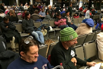 caption: Ken Peterson and Todd Rickdal at the free health clinic hosted at Key Arena Thursday morning.