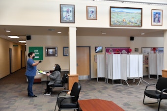 caption: A citizen of the Confederated Tribes of the Colville Reservation waits for her Covid-19 vaccination in this 2021 photo at Colville Tribes Indian Health in Nespelem, Washington. The Indian Health Service has a single doctor for the reservation, serving a population of about 5,000.