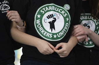 caption: Starbucks employees and supporters react as votes are read during a union-election watch party on Thursday, Dec. 9, 2021, in Buffalo, N.Y. Starbucks workers have voted to unionize over the company's objections, pointing the way to a new labor model for the 50-year old coffee giant.