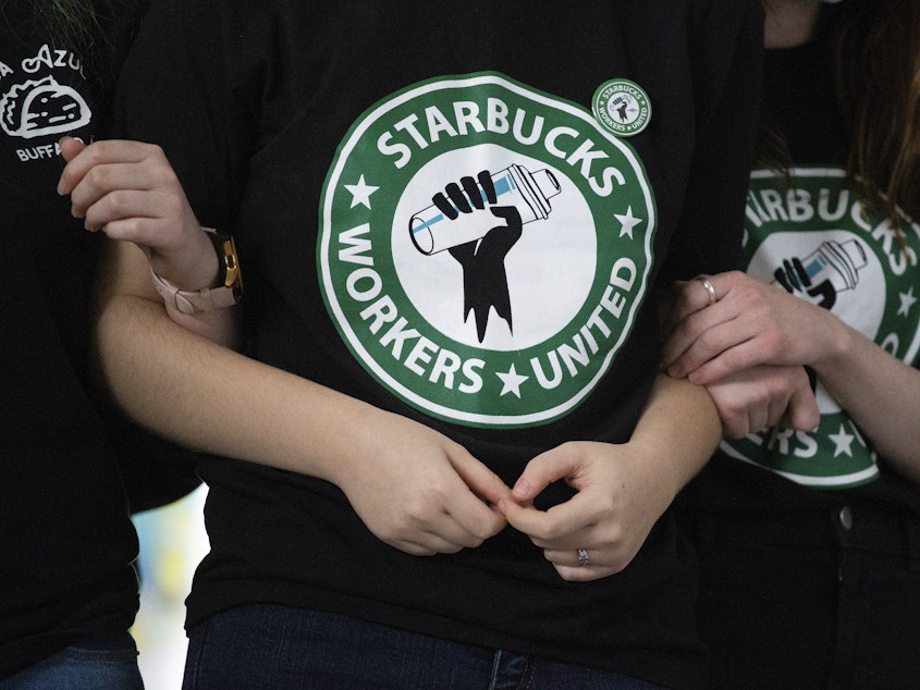 caption: Starbucks employees and supporters react as votes are read during a union-election watch party on Thursday, Dec. 9, 2021, in Buffalo, N.Y. Starbucks workers have voted to unionize over the company's objections, pointing the way to a new labor model for the 50-year old coffee giant.