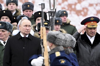 caption: Russian President Vladimir Putin and Defense Minister Sergei Shoigu (right) take part in a wreath-laying ceremony at the Tomb of the Unknown Soldier in Alexander Garden on Defender of the Fatherland Day, in Moscow, Friday.