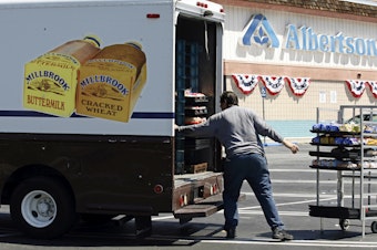 caption: FILE - Mitch Maddox, a bread route salesman, loads bread Tuesday, May 30, 2006, outside the Eagle Rock Albertsons store in Los Angeles. The Federal Trade Commission on Monday, Feb. 16, 2024, sued to block a proposed merger between grocery giants Kroger and Albertsons, saying the $24.6 billion deal would eliminate competition and lead to higher prices for millions of Americans.