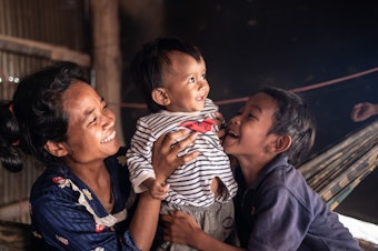 caption: Ten-month-old Ahmin Esas, who was born with clubfoot, shares a moment with his mother and brother in the family's home near Battambang, Cambodia. As a single parent with limited means, his mother, Pho Sok overcame many challenges to ensure her son could receive the treatment he needed.