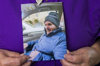 caption: Heidi Aurand holds a photo of her son Adam Aurand who cycled through the streets and jail and was at Washington state's largest psychiatric inpatient facility.