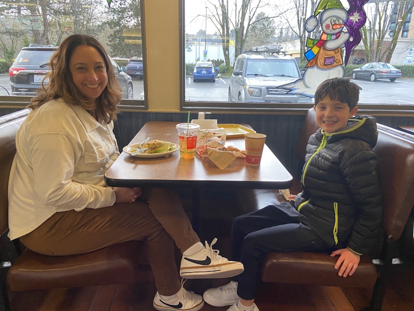 caption: Melissa Robbins (left) and her son, Aiden Robbins (right) grab lunch at the University District Burgermaster. 