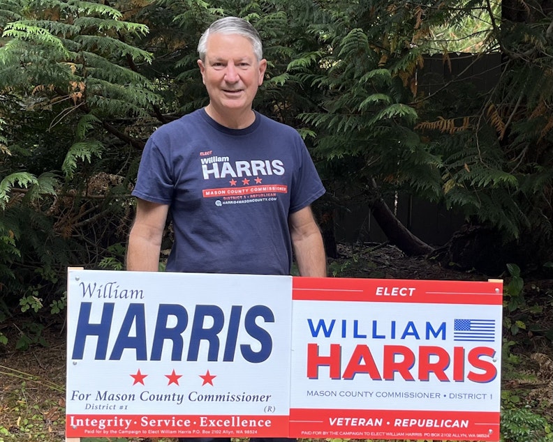 caption: William Harris with his old, pre-August sign on the left, and his new signs on the right.