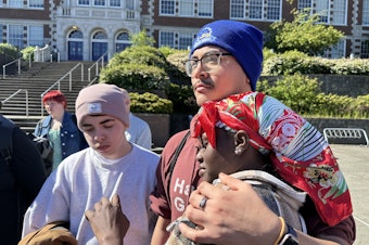 caption: Former Garfield High School student Karima Souleyman is comforted by friends. Souleyman spoke at a community gathering outside school on the morning after a student was fatally shot on campus. 