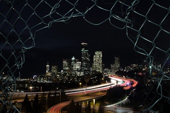 caption: The Seattle skyline at night, with I-5 running through downtown. 