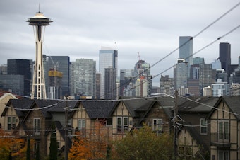 caption: Homes are shown in the foreground of downtown Seattle on Tuesday, October 16, 2024, along West Olympic Place in Queen Anne. 