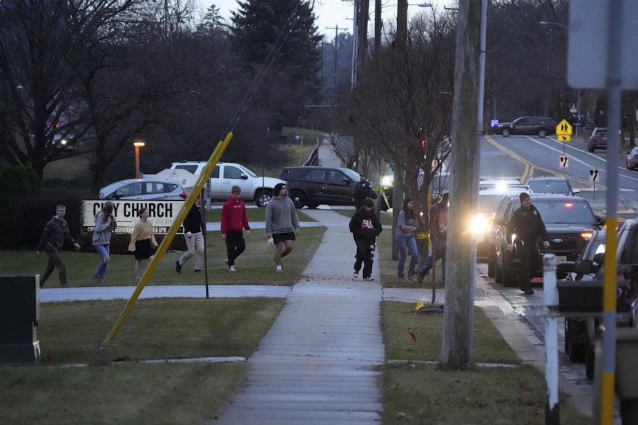 caption: Students walk to a bus as they leave the shelter following a shooting at the Abundant Life Christian School, Monday, Dec. 16, 2024.