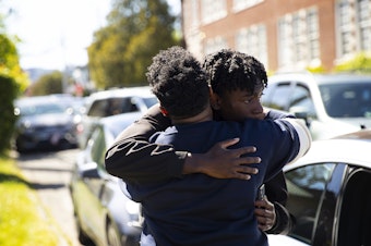 caption: Christle Young hugs her son after he was released from school following a deadly shooting of a student on Thursday, June 6, 2024, at Garfield High School in Seattle. 