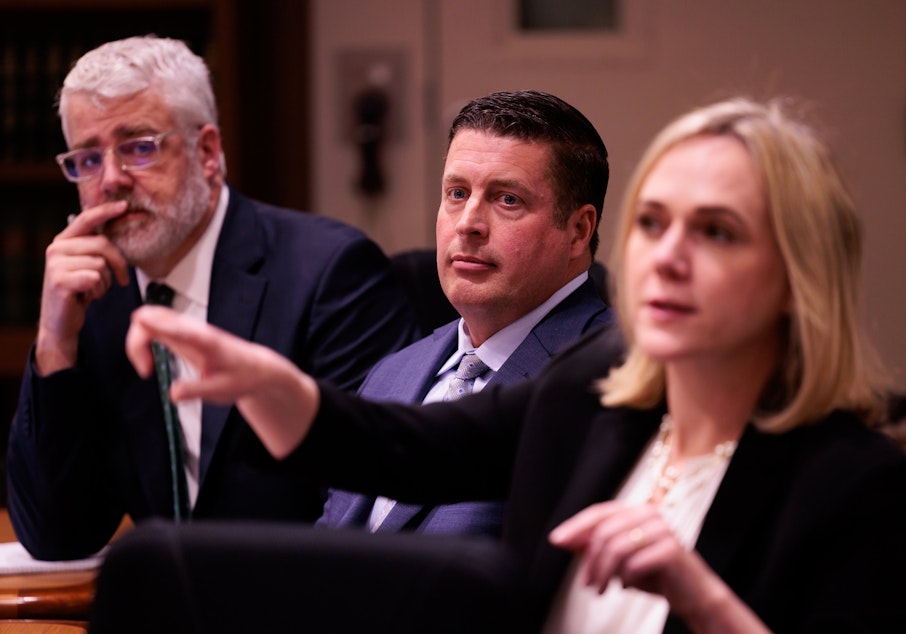 caption: Auburn Police Officer Jeffrey Nelson, center, is flanked by two of his defense attorneys Tim Leary, left, and Emma Scanlan, right, during closing arguments at Maleng Regional Justice Center in Kent, Wash. Thursday, June 20, 2024.