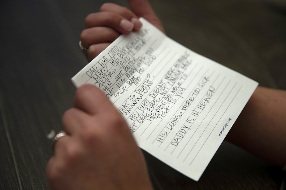 caption: Christy Maricle holds a letter that she wrote to her children after her husband, Kurt Mrsny, died of Covid in September of last year, at their home on Thursday, December 9, 2022, in Puyallup. 