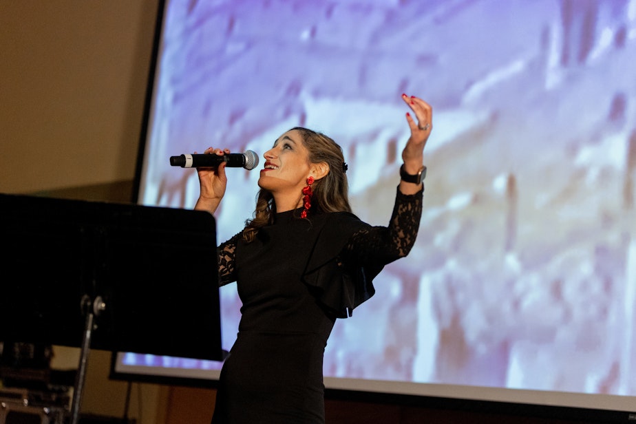 caption: Singer songwriter Sarah Aroeste performs for a crowd at "Muestros Artistas" in February 2023.