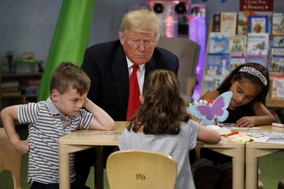 caption: Donald Trump visits with a group of children during his first term as president Friday, Aug. 24, 2018, in Columbus, Ohio. Trump's reelection has raised questions about education funding in Washington state and across the country.