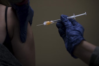 caption: Volunteer registered nurse Amy Rioux administers a Covid-19 vaccine on Wednesday, April 7, 2021, at Island Drug in Oak Harbor. 