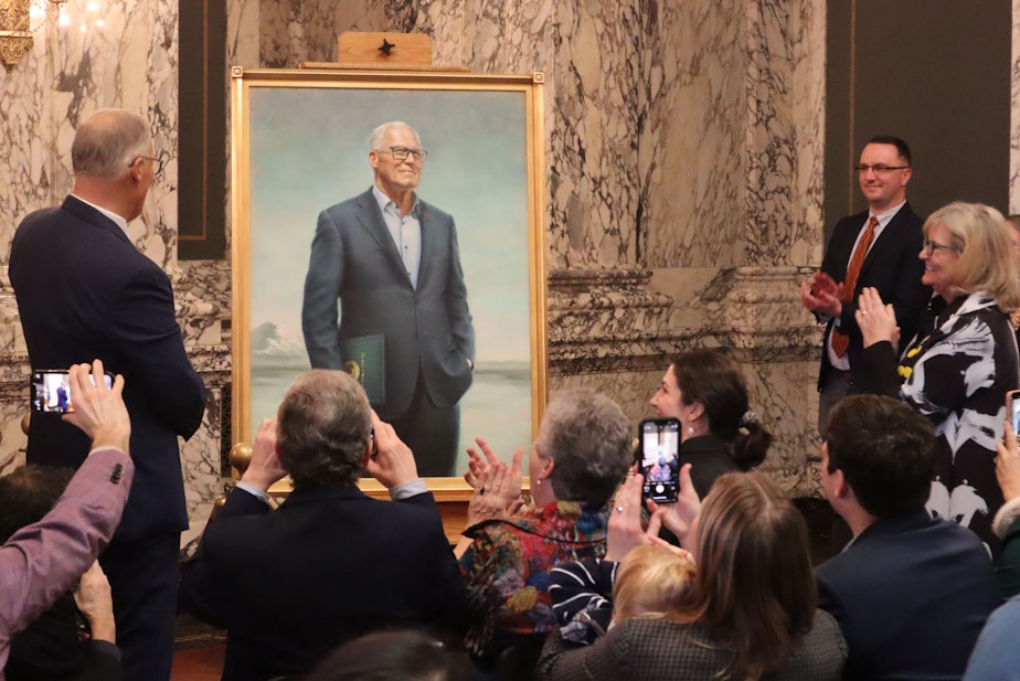 caption: Washington's 23rd governor, Jay Inslee, admires his official portrait after its unveiling Tuesday, Jan. 14, 2025. The portrait was painted by Seattle artist Grace Athena Flott, and will hang in the governor's office to memorialize Inslee's tenure in the role.