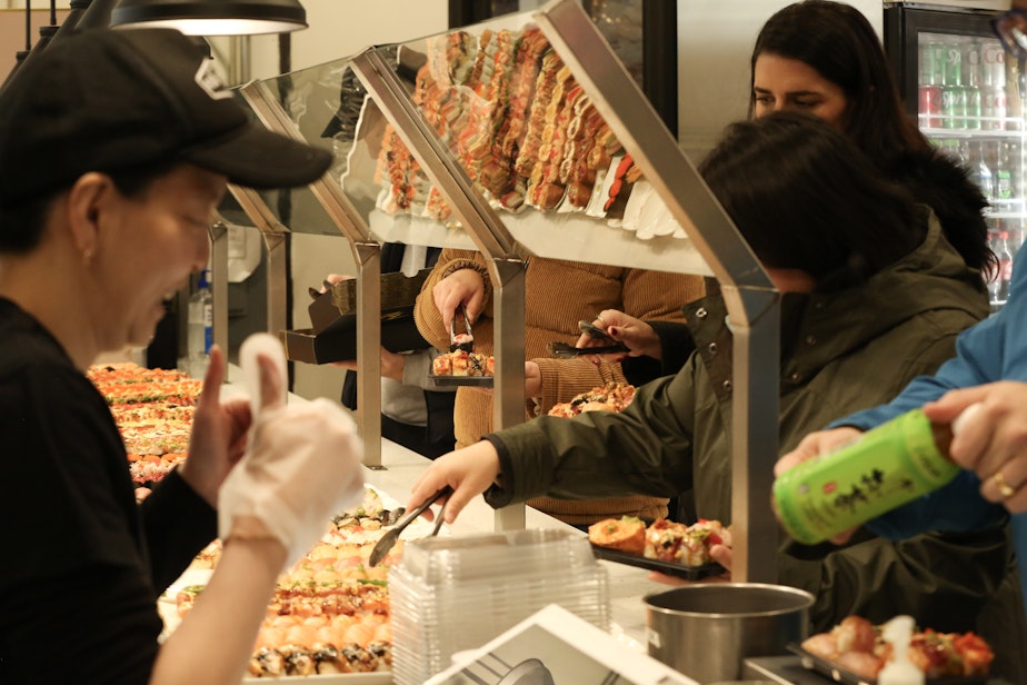 caption: Workers at FOB Sushi Bar in Seattle's Belltown neighborhood prepare the bar for its reopening on Dec. 3, 2024.