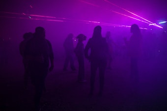 caption: People dance at an underground rave as DJs perform their sets on Friday, October 11, 2024, in Seattle. 