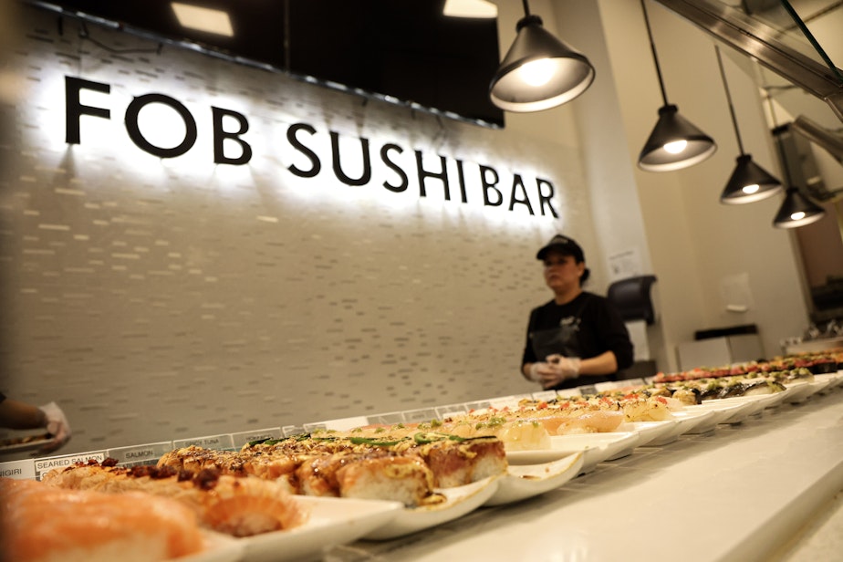 caption: Workers at FOB Sushi Bar in Seattle's Belltown neighborhood prepare the bar for its reopening on Dec. 3, 2024.