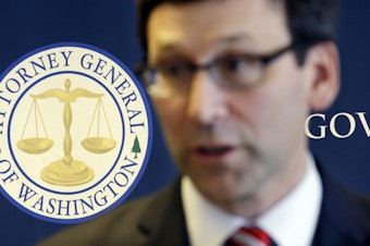 caption: In this March 6, 2017, file photo, the logo for the Washington State Attorney General's office stands behind as Attorney General Bob Ferguson speaks at a news conference, in Seattle.