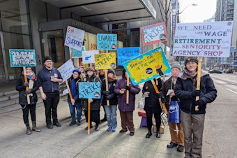 caption: Seattle Art Museum gallery guards picket outside the building entrance Wednesday, Dec. 4, 2024.