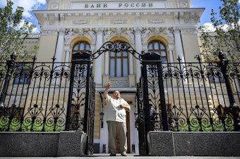 caption: A man waves to a taxi as he leaves the Russian Central Bank headquarters in downtown Moscow last summer. The EU approved a plan this week to use interest from hundreds of billions of dollars' worth of seized Russian assets to help fund Ukraine's military.