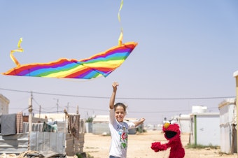 caption: In 2017, Sesame Workshop and the International Rescue Committee became the first winners of 100&Change for their work with children in the Middle East<em>.</em> Above, Elmo learns how to fly a kite at Azraq Camp, Jordan.