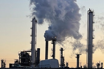 caption: Steam and invisible, heat-trapping carbon dioxide billow from the Marathon Petroleum Corporation refinery in Anacortes, Washington, in April 2022.