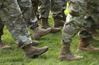 caption: FILE- In this April 3, 2017, file photo U.S. Army soldiers march in formation during a change of command ceremony at Joint Base Lewis-McChord in Washington. 