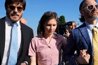 caption: Amanda Knox arrives flanked by her husband Christopher Robinson, right, at the Florence courtroom in Florence, Italy, on Wednesday.
