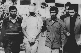 caption: A U.S. hostage during the 1979 Iran hostage crisis is displayed to the crowd outside the U.S. Embassy in Tehran. The Iran hostage crisis was a stain on Carter's presidency that helped doom a second term.