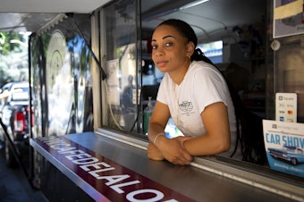 caption: Dani Smith, co-owner of Café de la Loba, is portrayed on Friday, July 19, 2024, while working a private event outside of the Filipino community center in Seattle. 