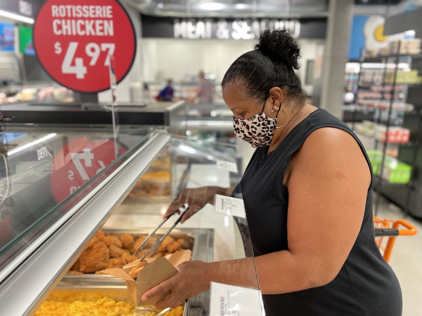 caption: Victoria Beach fills a box with foods from the hot bar at Amazon Fresh