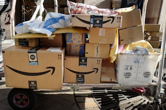 caption: Amazon Prime packages are loaded on a cart for delivery in New York. 