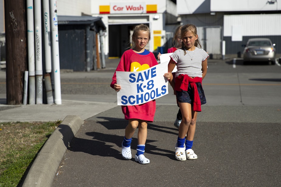 caption: Maribel Vrooman, 9, and Nora Ward, 9, students at Catherine Blaine K-8, arrive at a rally in support of keeping schools open ahead of the Seattle Public Schools board meeting on Wednesday, September 18, 2024, at the John Stanford Center for Educational Excellence building in Seattle. 