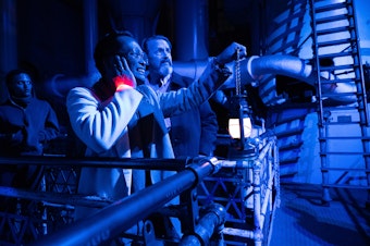 caption: Audience members watch as actors climb a ladder in the 118-year-old Georgetown Steam Plant in October 2024.