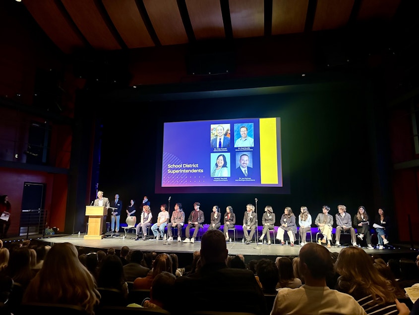 caption: Mercer Island Superintendent Fred Rundle speaks at a town hall on the state's school funding crisis at Sammamish High School in Bellevue. More than 450 people packed the school auditorium to fight for a funding boost.