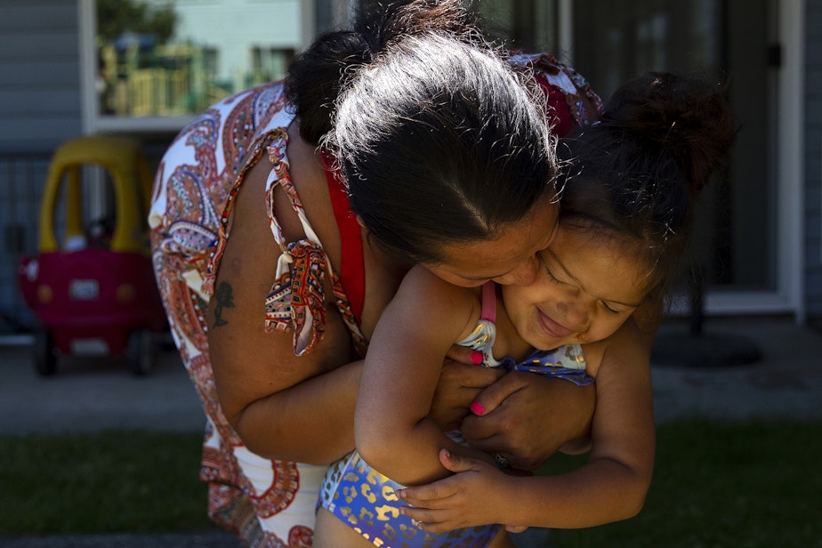 caption: Tynikki Arnold kisses her 5-year-old daughter Vay’s cheek while playing outside of their apartment on Friday, July 15, 2022.