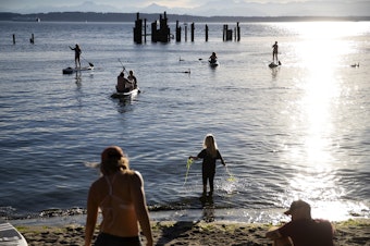 caption: Beachgoers enjoy the sun at Point Shilshole Beach, a privately owned beach open to the public, on Tuesday, June 25, 2024, in Seattle. 