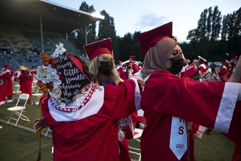 caption: Cleveland Stem High School seniors celebrate after graduating in-person on Tuesday, June 15, 2021, at Memorial Stadium in Seattle. 