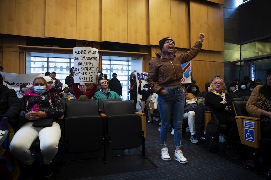 caption: Rosario Lopez leads a chant in Council chambers following public comment after asylum seekers, activists and allies marched to Seattle City Hall to ask for assistance with housing on Tuesday, February 27, 2024, in Seattle. Seattle City Council members abruptly left Council chambers. 