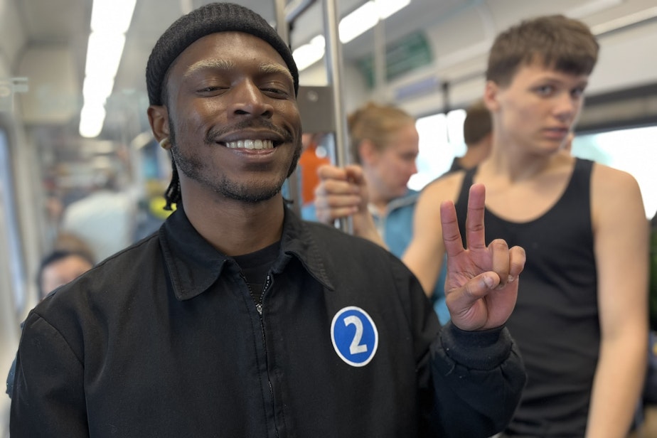 caption: Corey Mae Lamont wears a jacket he designed to commemorate the opening of the Two Line connecting South Bellevue to South Redmond.