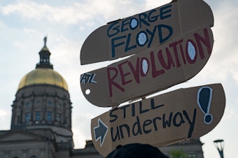 caption: People gather to memorialize the life of George Floyd on the first anniversary of his death on Tuesday in Atlanta. America's corporations pledged to boost diversity soon after his death last year, but progress can be slow.