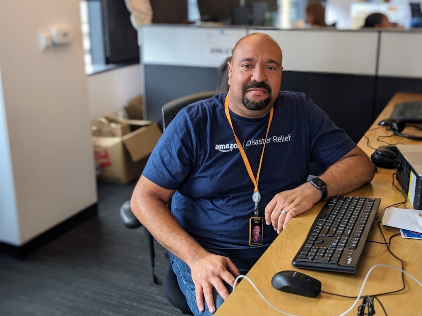 caption: Abe Diaz, head of Amazon Disaster Relief, sits at his desk at the company's headquarters in Seattle.