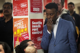 caption: Hassan Diis reacts as early election results show councilmember Kshama Sawant trailing behind her District 3 opponent Egan Orion on Tuesday, November 5, 2019, during an election night party at Langston Hughes Performing Arts Institute in Seattle. 