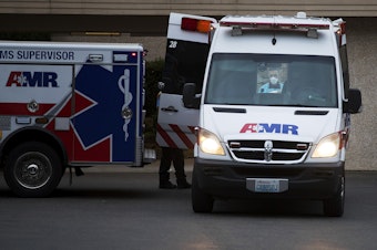 caption: A first responder lifts a patient into the back of an ambulance at the Life Care Center of Kirkland, the epicenter of the coronavirus outbreak in Washington state, on Thursday, March 5, 2020, in Kirkland.