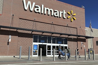 caption: Shoppers exit a Walmart store, on Feb. 21, 2024, in Englewood, Colo. Walmart on Tuesday announced layoffs affecting several hundred jobs at the retail giant's campus offices.